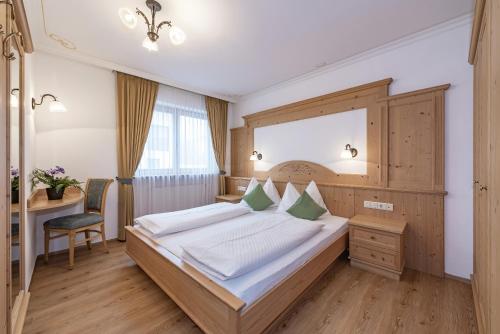 a bedroom with a large bed and a desk at Residence Diana Apartment 303 in Terento