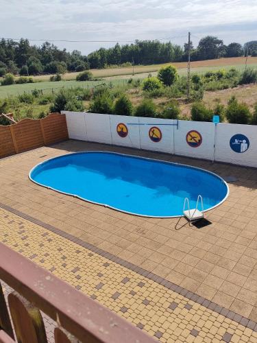 a small blue swimming pool on a brick patio at Ptasi Raj in Karwia