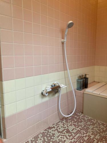 a shower in a bathroom with pink tiles at Guest House Sun-Sui 鎌倉 in Kamakura