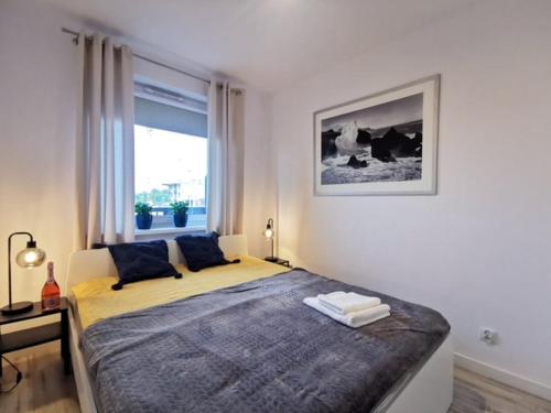 sypialnia z dużym łóżkiem przed oknem w obiekcie Apartament nad morzem FABIO Kołobrzeg w Kołobrzegu