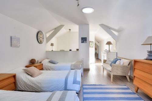 - une chambre avec deux lits, une chaise et un réveil dans l'établissement Villa traditionnelle pour 8 - 550m de la plage, à Noirmoutier-en-l'lle