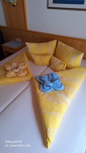 a bed with yellow pillows and blue flowers on it at Haus Alpina in Kaunertal