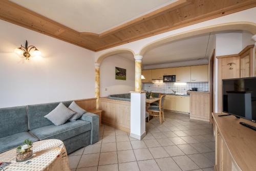 a living room with a couch and a kitchen at Residence Diana Apartment 302 in Terento