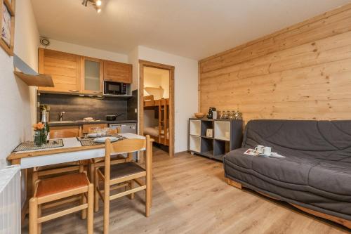 una cucina e un soggiorno con un divano e un tavolo di Chamonix Sud - Grepon 102 - Happy Rentals a Chamonix-Mont-Blanc