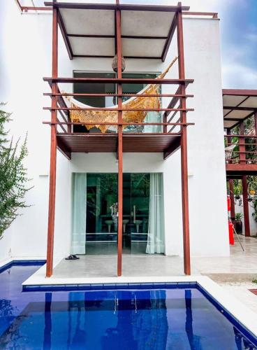 a house with a balcony over a swimming pool at La Reserve Villa Tropicana in Pipa