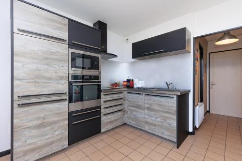 - une cuisine avec des portes coulissantes en bois et une cuisinière dans l'établissement MimiZen - Vue sur locéan la plage de la Garluche, à Mimizan