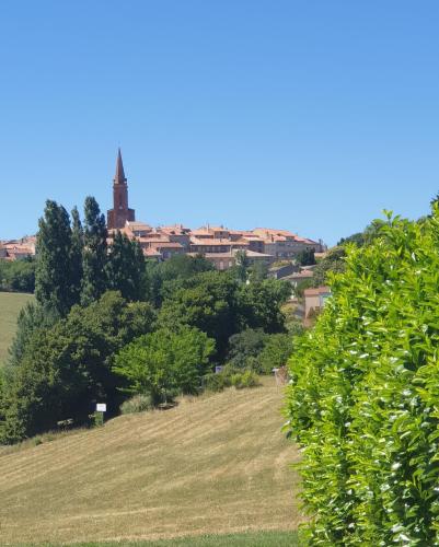 - une vue sur une ville depuis un champ arboré dans l'établissement Le Loft, à Caraman
