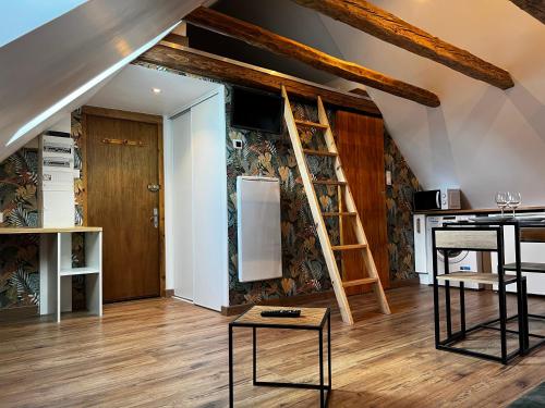 - un salon avec une échelle et un réfrigérateur dans l'établissement Cocon sous les toits du Gévaudan, à Marvejols