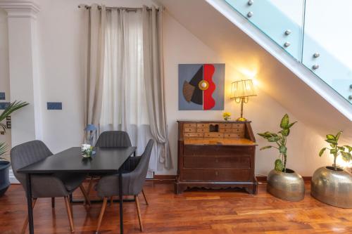 a dining room with a table and chairs and a staircase at L' Hôtellerie Easy Suites in Palermo