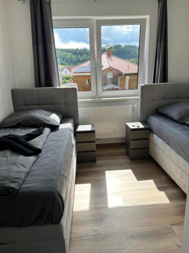 a bedroom with a bed and a couch and two windows at Wohnung mit 3 Schlafzimmern nahe Red Bull Ring in Trofaiach