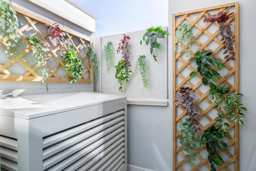 a room with plants on the wall at Taro's Blue Sea Apartment by Pleiades Home in Marina di Pisa