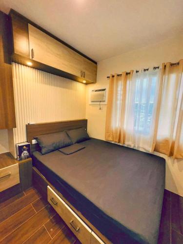 a small bedroom with a large bed in a room at Modern 1-Bedroom Condo at Matina Enclaves Residence, Close to SM City Davao in Davao City