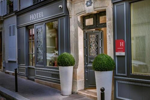a store front with two potted plants in front of it at Le Relais Montmartre in Paris