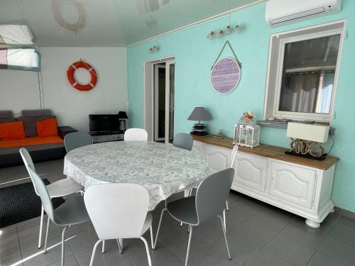 une salle à manger avec une table, des chaises et un canapé dans l'établissement Residence du Grand Large, à Marseillan