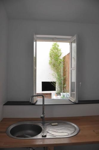d'un évier dans une cuisine avec une fenêtre. dans l'établissement Appartement Terrasse Plage, à Biarritz