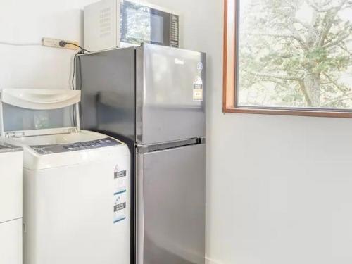 a refrigerator in a kitchen next to a window at 别墅中的一间客房 in Auckland
