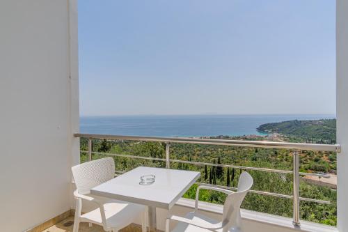 a balcony with a table and chairs and the ocean at Aphrodite's Garden in Himare
