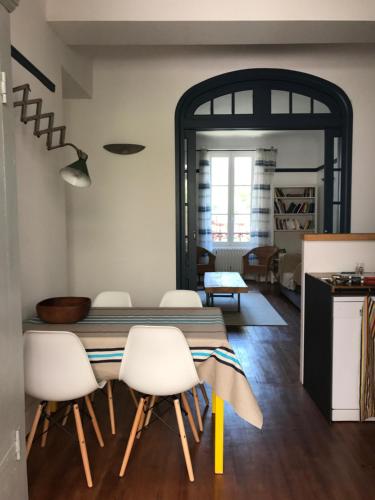 une salle à manger avec une table et des chaises blanches dans l'établissement Appartement Terrasse Plage, à Biarritz