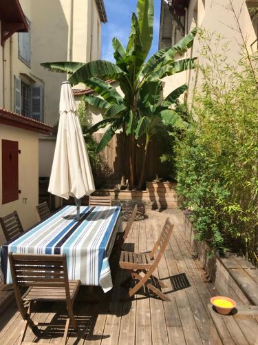 a table with an umbrella and chairs on a patio at Appartement Terrasse Plage in Biarritz