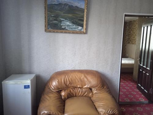 a brown leather chair in a room with a mirror at ОРДА in Shymkent