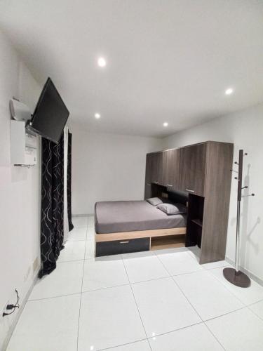 une chambre avec un lit et une télévision à écran plat dans l'établissement Maisonnette entière, à Ivry-sur-Seine