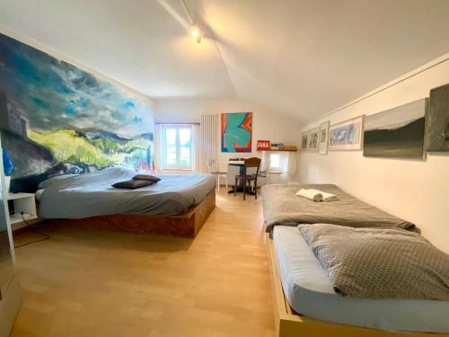 a bedroom with two beds and a table in it at Café du Soleil in Saignelégier