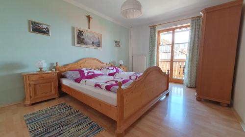 a bedroom with a wooden bed and a window at Ferienhaus Oberirlerhof in Anger