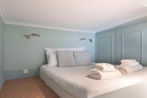 une chambre avec un lit avec des serviettes dessus dans l'établissement Pick A Flat's Apartment in Saint-Germain des Près - Rue Paul Louis Courier, à Paris