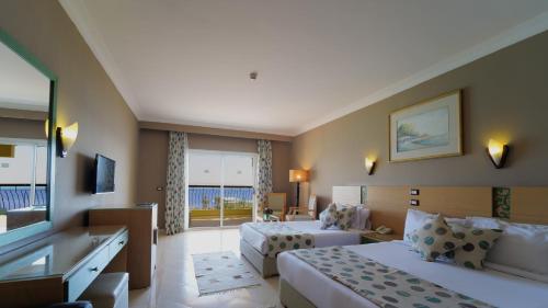 a hotel room with two beds and a television at Regina Resort and Aqua Park Hurghada in Hurghada
