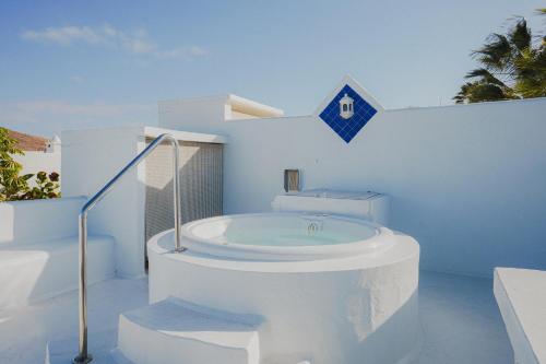 Un baño blanco con una bañera en una pared blanca. en Villa Ananda - Luxury Villa in Bahiazul, en Corralejo