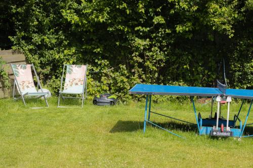 two chairs and a ping pong table in a yard at Ferienwohnungen Fehmarn mit Parkplatz in Petersdorf in Fehmarn