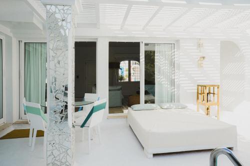 una habitación blanca con una cama y una mesa en Villa Ananda - Luxury Villa in Bahiazul, en Corralejo