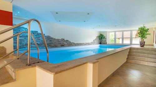 a swimming pool with blue water in a building at Huberhof in Ruhpolding