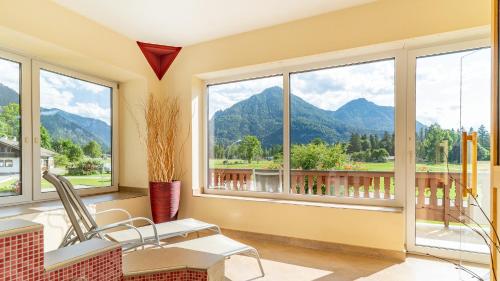 a room with windows with mountains in the background at Huberhof in Ruhpolding