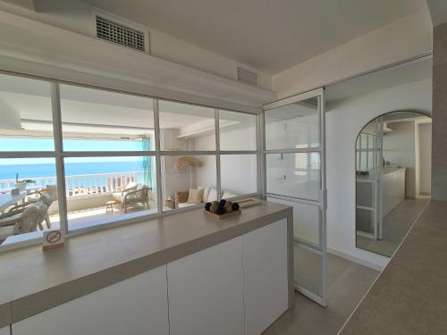 a white kitchen with a view of the ocean at eme de Maison - luxury only two in Arenales del Sol