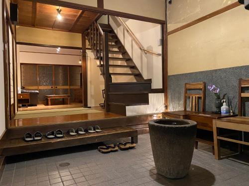 uma sala com uma escada e um monte de sapatos em Atagoya em Takayama