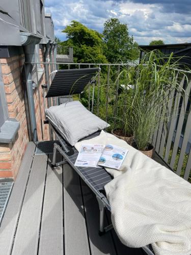 a balcony with two pillows and a table on it at Meerzeit in Eckernförde