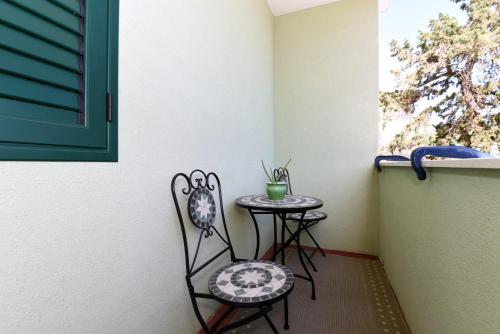 a small table and chair next to a window at Apartment Happy place in Baćina