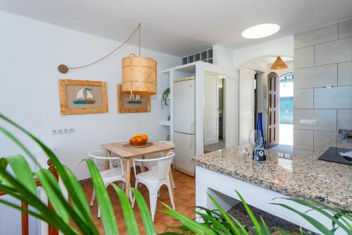 a kitchen with white walls and a table and chairs at Eslanzarote Varadero House, super wifi in Tías
