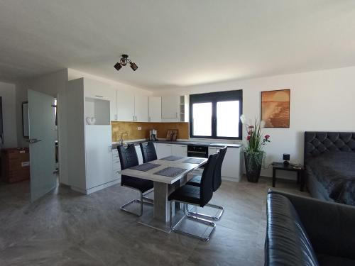 a kitchen and living room with a table and chairs at Apartmani Kasa in Rap