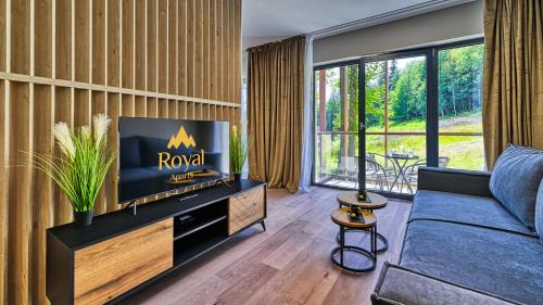 a living room with a tv and a couch at Źródło Izery przy gondoli VIP Sauna, Siłownia, Bawialnia by Royal Aparts in Świeradów-Zdrój