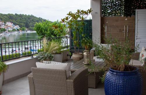 a balcony with chairs and potted plants and a river at Harbour View House in Zaton