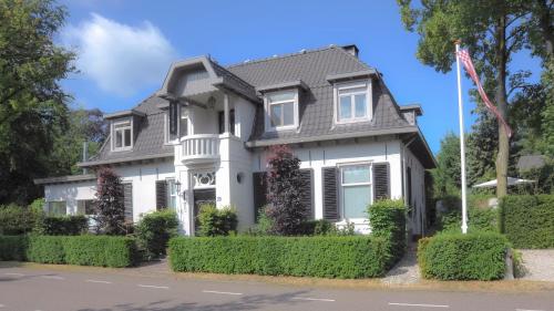 a white house with a gray roof at de Heeren van Hal in Esch