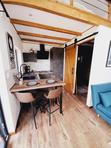 une cuisine avec une table en bois et un canapé bleu dans l'établissement Cozy Tiny House plus SPA - à Pereille d'en Haut, à Péreille
