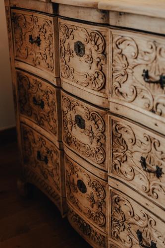 a wooden dresser with intricate designs on it at Hôtel l'Abbaye in Saint-Cyprien