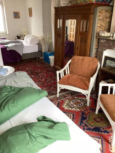 a room with two beds and a chair and a table at Au 81 in Liège
