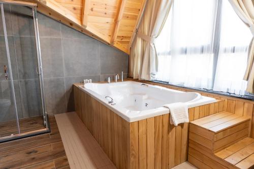 a bathroom with a large tub and a shower at Hancioglu Orman Evleri & Hotel in Trabzon