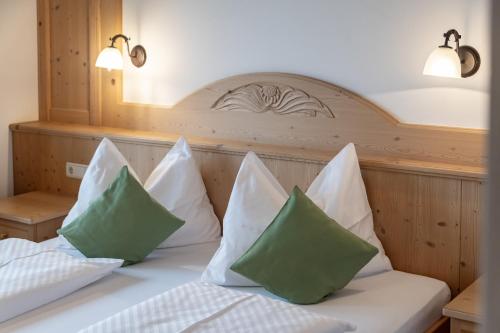 a bed with green and white pillows on it at Residence Diana Apartment 301 in Terento