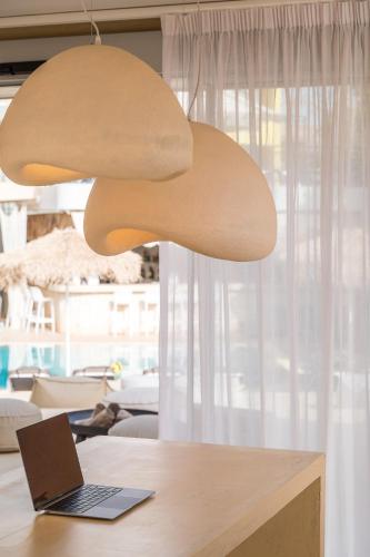 a light hanging over a desk with a laptop at Sunshine Boutique Hotel by Estia in Malia