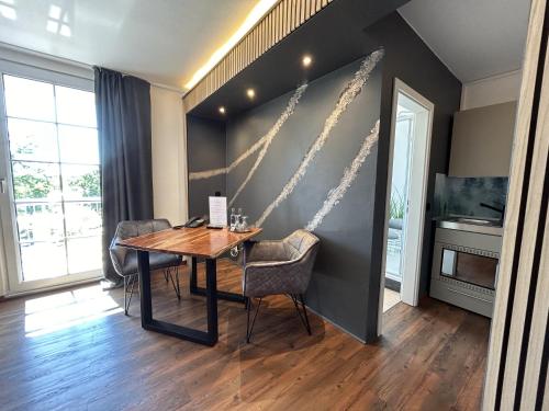 a dining room with a wooden table and chairs at Balkon-Studio im Hotel Reindahls in Wilkendorf